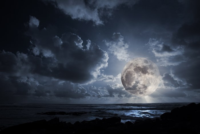 Full moon over the ocean at night