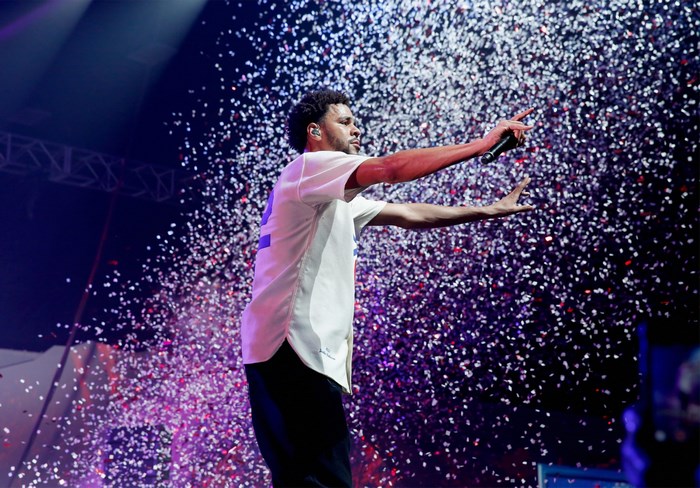 J. Cole performing on stage with confetti