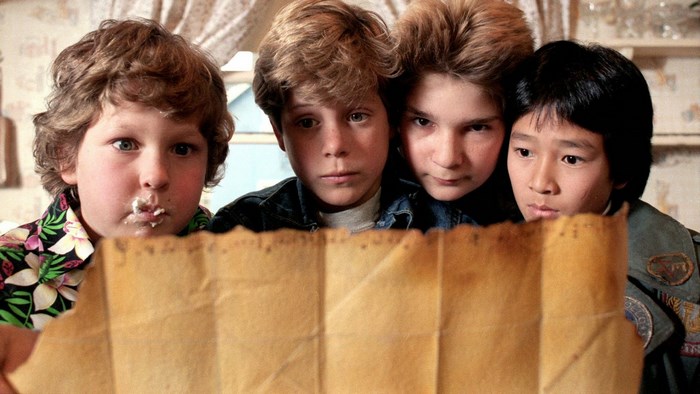 The Goonies looking at a map