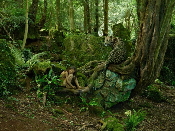 A young girl and a leopard in a forest