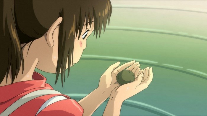 Chihiro from Spirited Away holding a small object