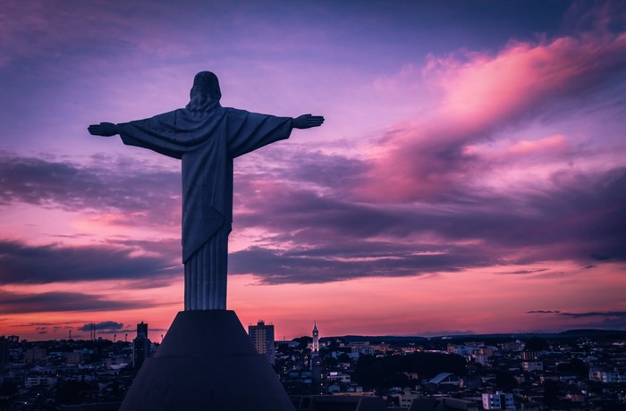 Christ the Redeemer statue overlooking city at sunset