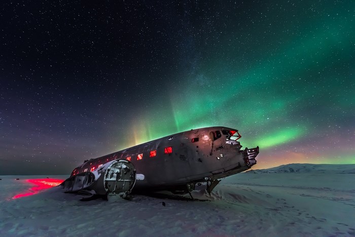 Abandoned airplane under the aurora borealis