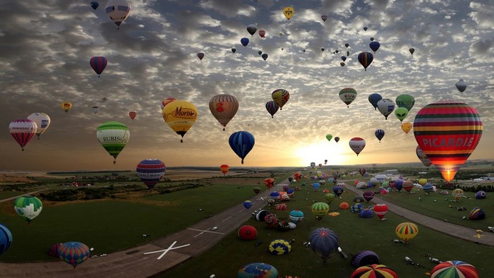 Hot Air Balloons Ascending Over a Field at Sunrise