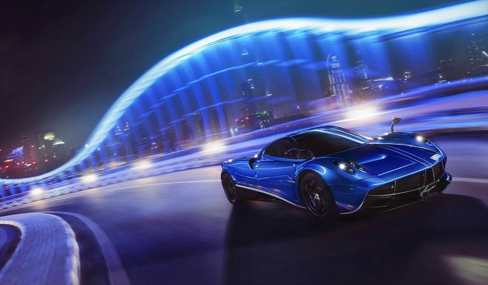 Blue Pagani Huayra driving on a highway at night