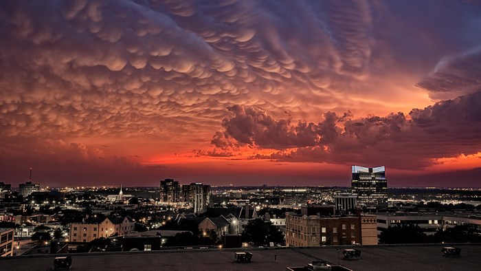 Mammatus clouds over city at sunset