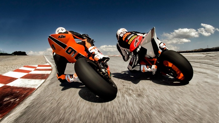 Two KTM motorcycle racers on a track