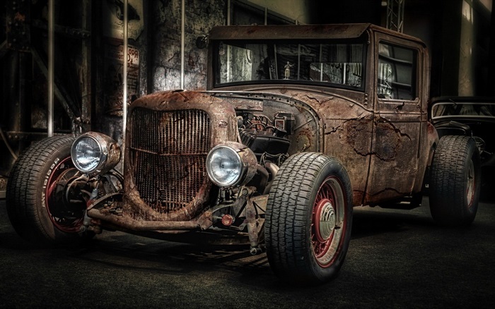 Rusty hot rod car in a dark garage
