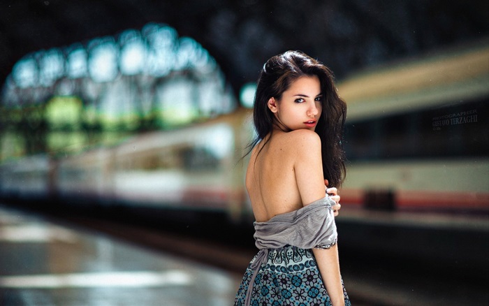 Woman in a patterned dress on a train platform