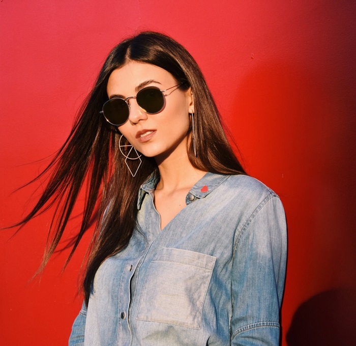 Victoria Justice wearing sunglasses and denim shirt