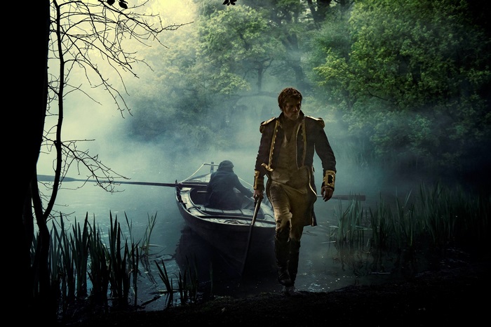 Man in military uniform by a boat