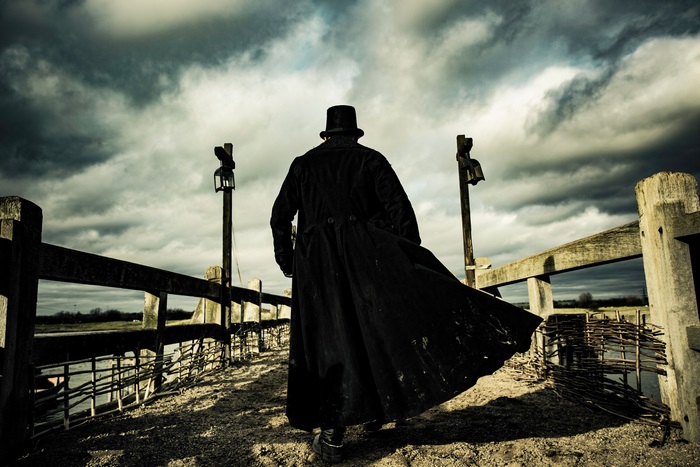 Man in black coat and top hat walking