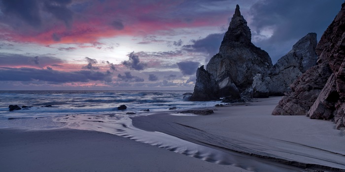 Beach with rock formations at sunset 4K