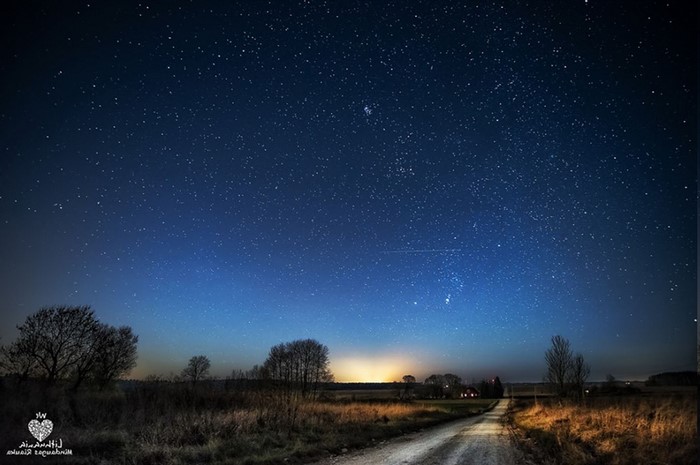 Starry night sky over a rural landscape in Lithuania