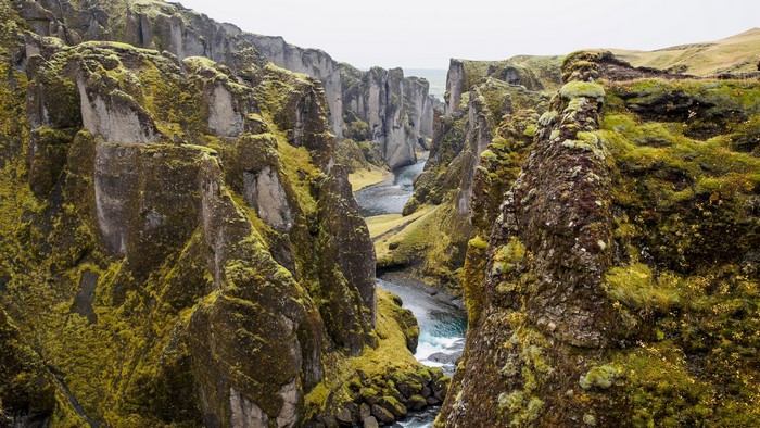 Moss-covered cliffs and river in a canyon