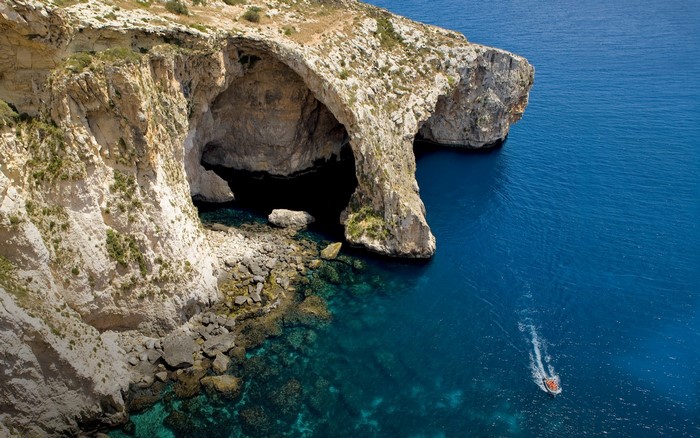 Sea cave and cliffs with a boat in Malta