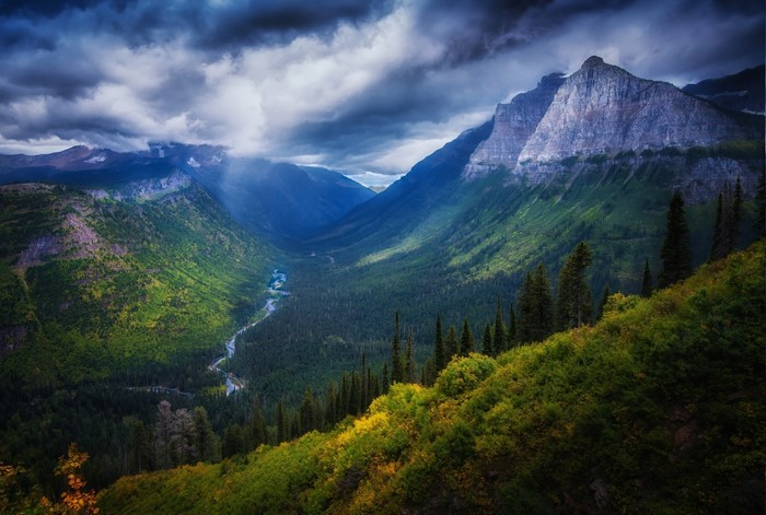 Valley with Mountains, Forest, and River under Cloudy Sky
