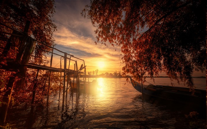 Sunset over a lake with a dock and boats