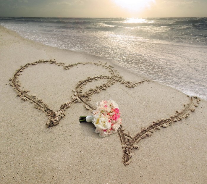 Two Hearts Drawn in Sand with Flower Bouquet