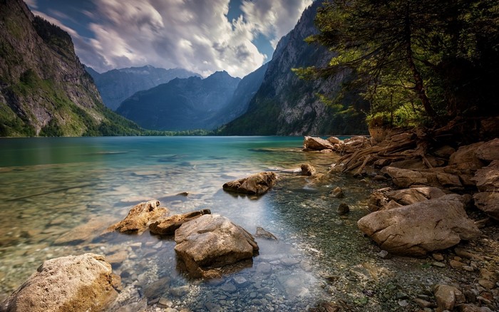 Mountain lake landscape with rocky shore and trees