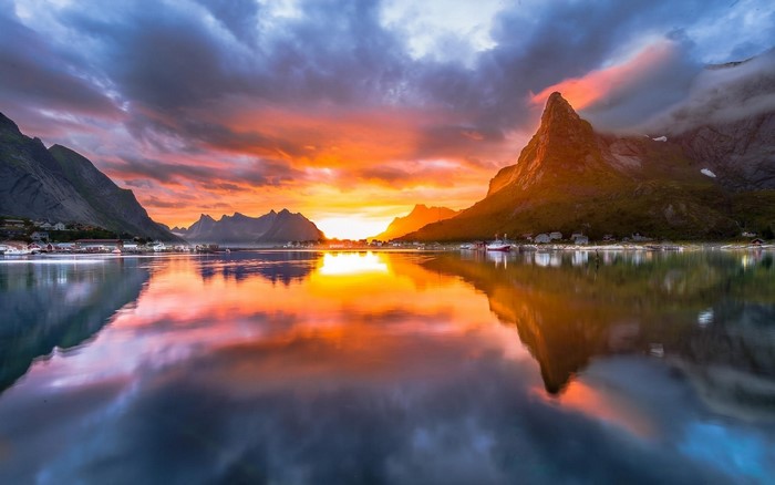 Sunset over a Norwegian fjord with mountains and village
