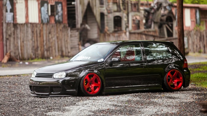Black Volkswagen Golf MK4 with red wheels