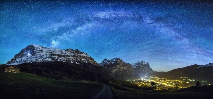 Milky Way over Snowy Mountains and Village