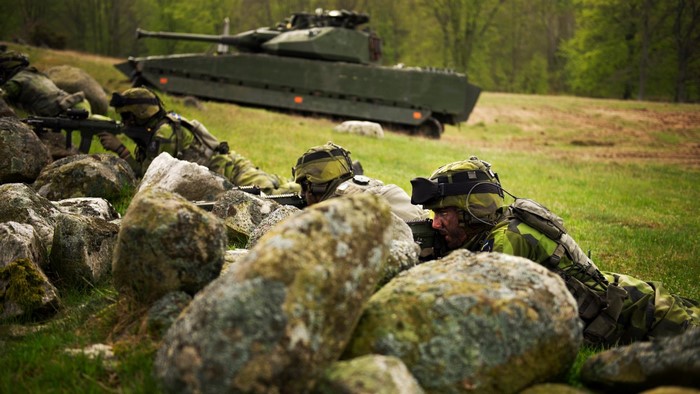 Swedish Army soldiers with CV90 infantry fighting vehicle