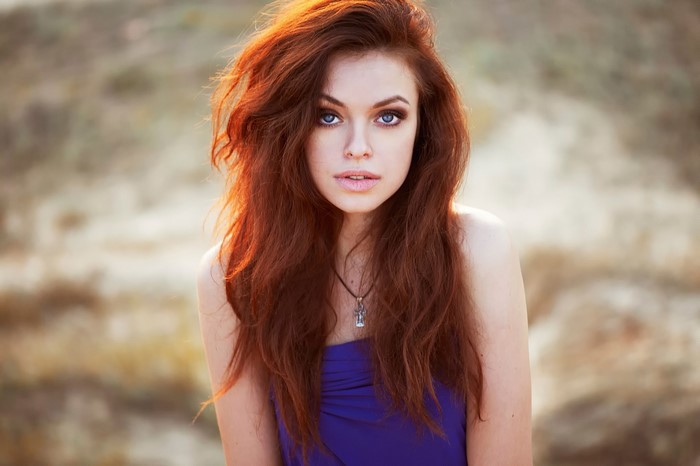 Redhead woman with blue eyes wearing a purple dress