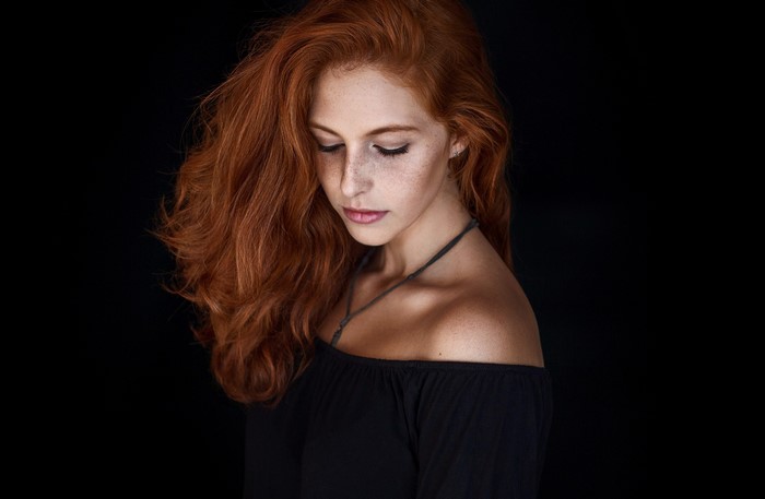 Redhead woman with freckles wearing black off-the-shoulder top