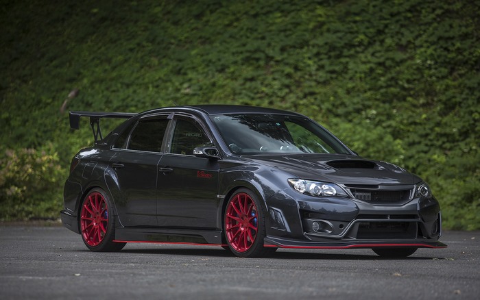 Dark Subaru Impreza WRX STI with red wheels