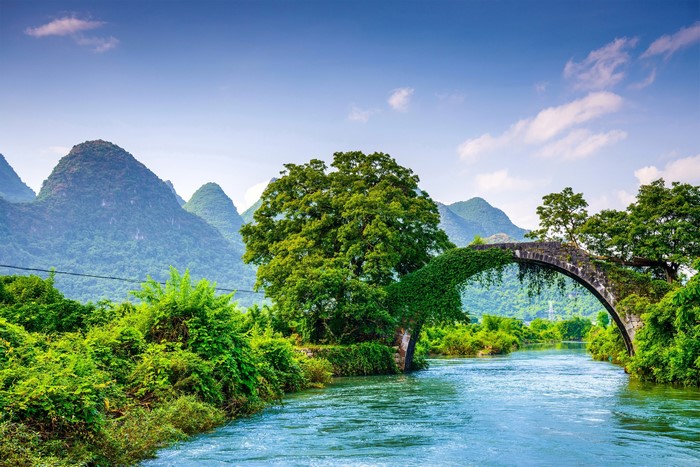 Yulong Bridge over a river with karst mountains