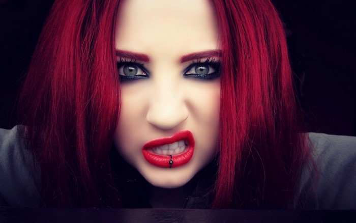 Redhead woman with green eyes and lip piercing