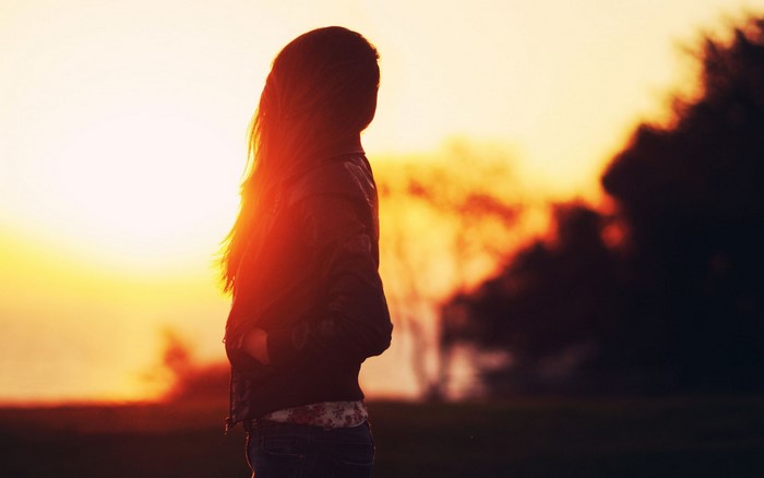 Silhouette of a woman with long hair at sunset