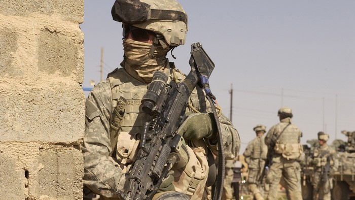 Soldier with M249 machine gun near a wall