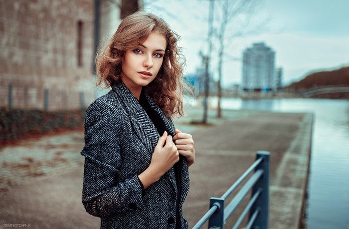 Woman with curly hair wearing a coat outdoors