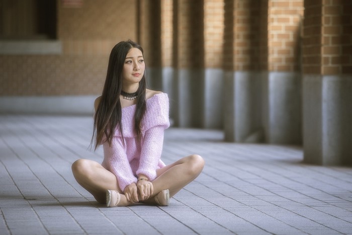 Asian woman sitting on the floor outdoors