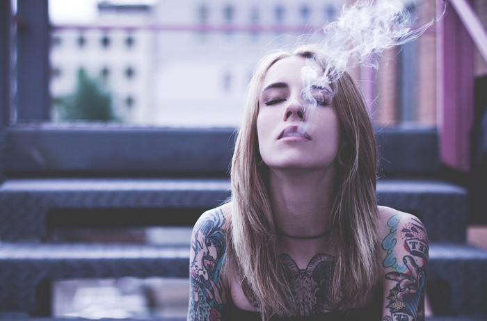 Woman with tattoos smoking