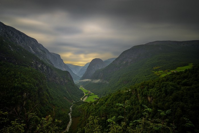 Valley with river and mountains under cloudy sky