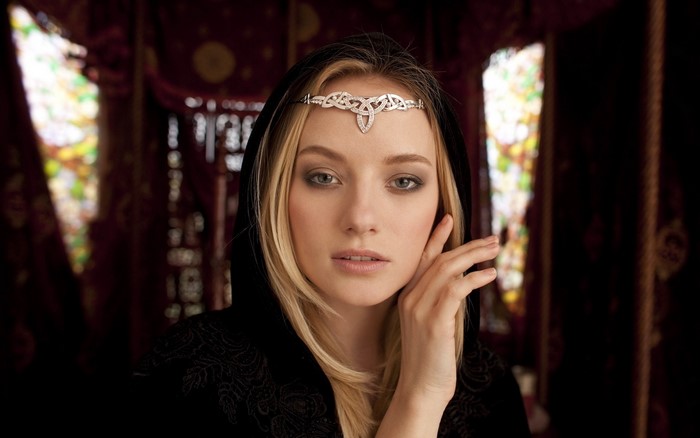 Woman with blonde hair and tiara wearing a black hood