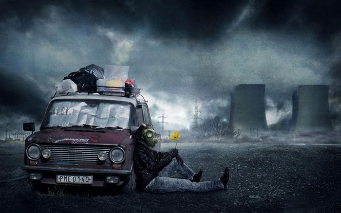 Person in gas mask with flower by car near cooling towers