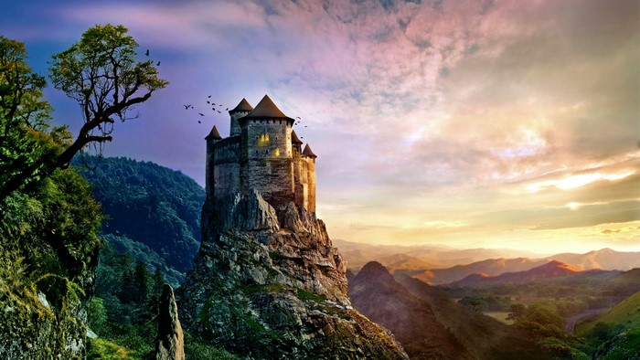 Castle on a rocky mountain peak at sunset