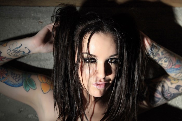 Woman with dark hair and tattoos