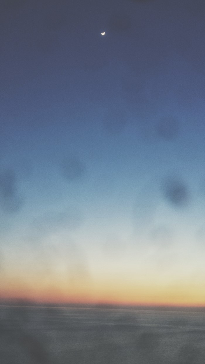Crescent moon over the ocean at sunset
