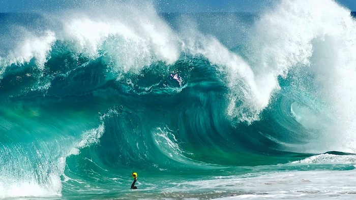 Surfer in a massive ocean wave