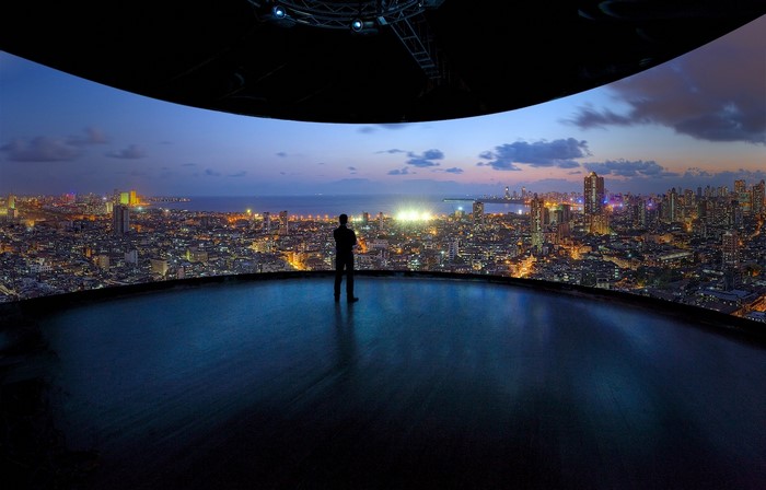 Man overlooking Mumbai cityscape at dusk from a curved platform