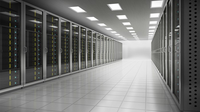 Server room with rows of data racks and ceiling lights