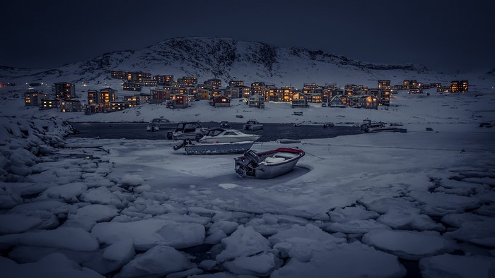 Winter village by the frozen sea in Greenland at night