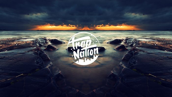 Trap Nation logo over rocky shore at sunset
