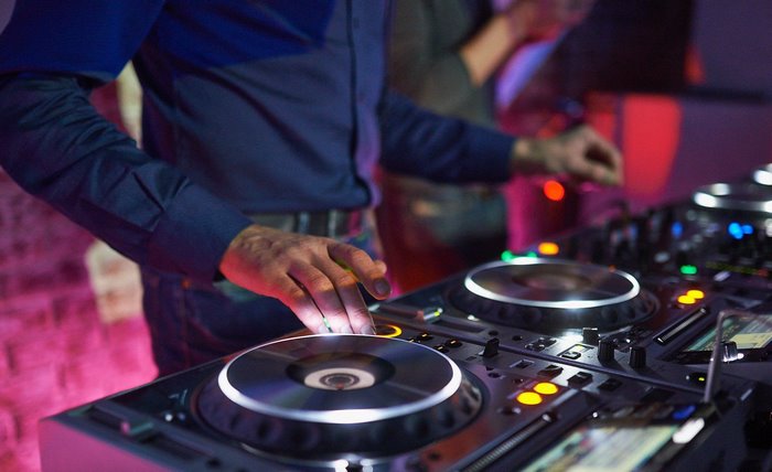 DJ mixing music on turntables and consoles